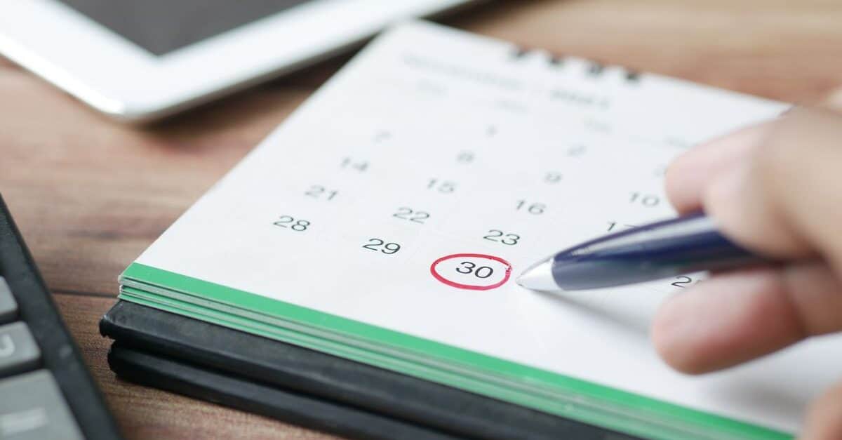 Calendari de sobretaula amb una data marcada en vermell al costat d'una calculadora
